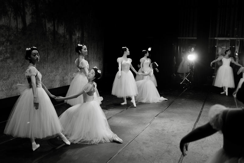 Black and white photograph of ballet dancers preparing backstage, reflecting harmony, coordinated movement and quiet elegance similar to Esinama’s harmonised family fashion.